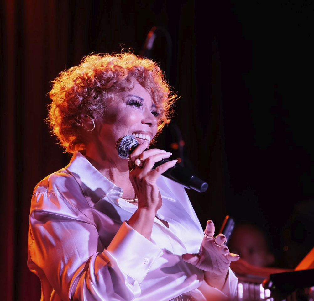 Amber Weekes performing against illustrated artwork