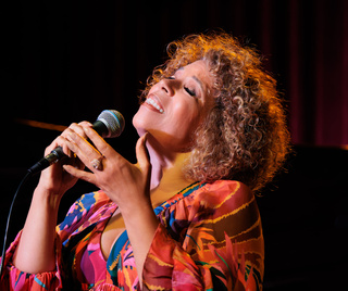 Amber Weekes singing into a microphone